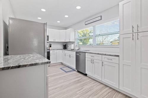 a kitchen with white cabinets and a stainless steel refrigerator at Nature's Coast Retreat in Spring Hill