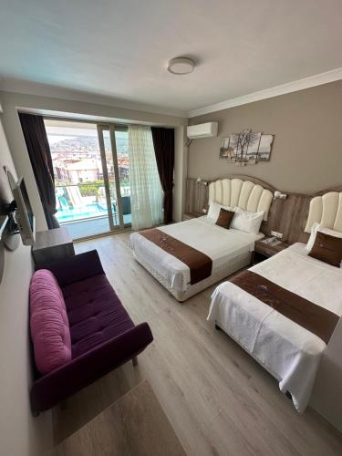 een hotelkamer met twee bedden en een bank bij Ceti̇n Presti̇ge Resort in Erdek
