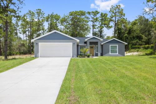 a house with a garage and green grass at The Quiet Oasis in Weeki Wachee