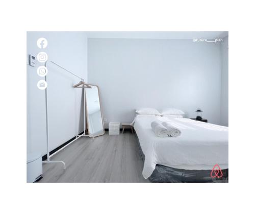 een witte slaapkamer met een bed en een spiegel bij Future Plan Airbnb in Tawau