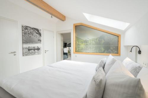 ein weißes Schlafzimmer mit einem großen Bett mit Kissen in der Unterkunft bichl 761 in Fischen im Allgäu