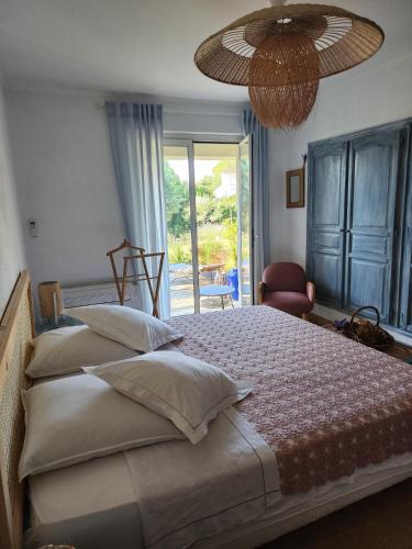 une chambre avec un grand lit et une grande fenêtre dans l'établissement Provence chic, piscine naturelle, détente spa - jacuzzi pour 2, à Besse-sur-Issole