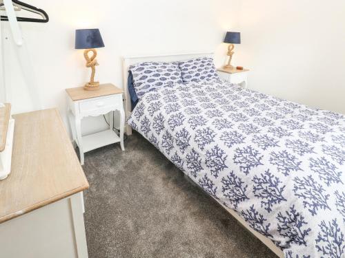 1 dormitorio con 1 cama azul y blanca y 2 mesitas de noche en 20 The Walled Garden en Penryn