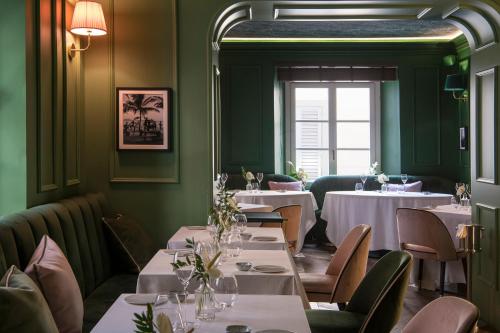 un restaurant avec des tables et des chaises blanches et une fenêtre dans l'établissement Hotel La Gemma, à Florence