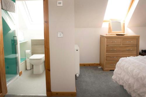 a bathroom with a bed and a toilet and a dresser at Seafront holiday home in Findochty in Findochty