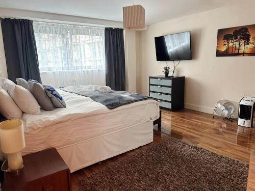 a bedroom with a bed and a television in it at Canary Wharf - Luxury Apartments in London