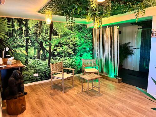 a room with two chairs and a jungle mural at Le Maquis Rooms in Plan dʼAups