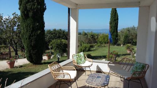 - une terrasse couverte avec des chaises et une table offrant une vue dans l'établissement Agriturismo Santa Maria, à Marta