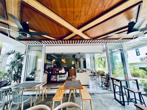 a restaurant with wooden ceilings and tables and chairs at Field-D House in Koh Tao