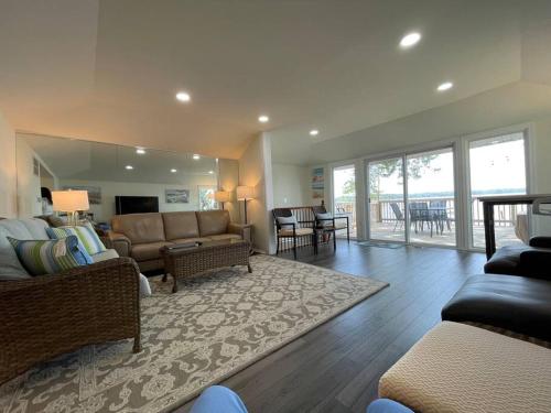 a large living room with a couch and a living room with a table at Waterfront Home with Private Beach, Stunning Views in Middle River