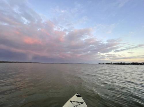 a boat in the water under a cloudy sky at Waterfront Home with Private Beach, Stunning Views in Middle River