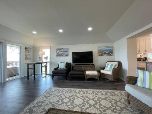 a living room with a tv and a couch and a table at Waterfront Home with Private Beach, Stunning Views in Middle River