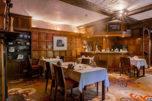 a dining room with two tables and a bar at Muthu Belstead Brook Hotel in Ipswich