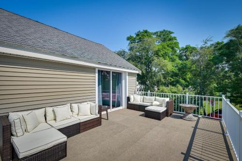 a patio with couches and tables on a balcony at Weymouth Waterfront Getaway with Swim Spa and Hot Tub in Weymouth