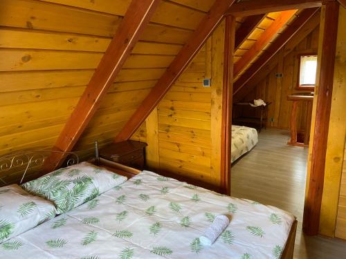 - une chambre avec un lit dans une cabane en bois dans l'établissement R&S Domki, à Darłowo