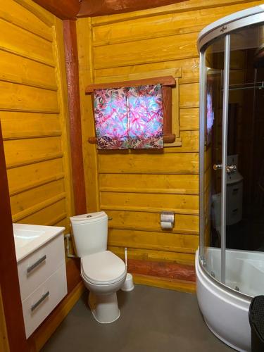 La salle de bains est pourvue de toilettes, d'un lavabo et d'une baignoire. dans l'établissement R&S Domki, à Darłowo