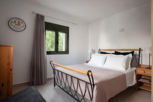 a bedroom with a bed with white sheets and a window at K Waterfront Residence In Mani in Áyios Kiprianós