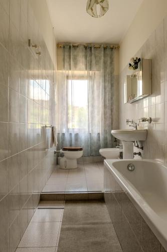 a bathroom with a tub and a toilet and a sink at B&B Locanda Sant'Antimo in Montalcino