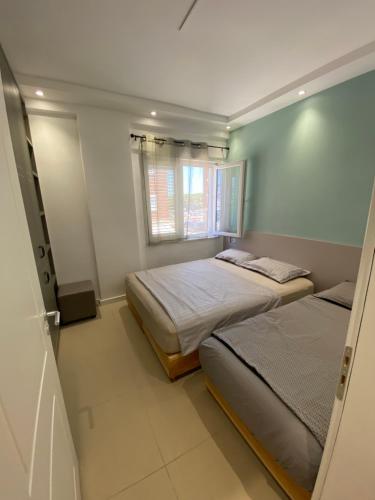 a bedroom with two beds and a window at Apartment Ferizaj in Velipojë