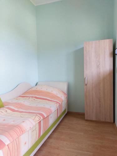 a bedroom with a bed and a wooden door at Apartman Žabljak in Žabljak