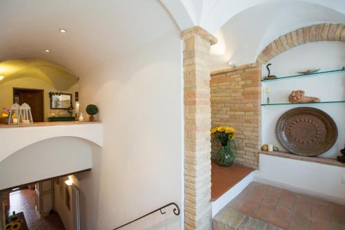 sala de estar con chimenea y pared de ladrillo en Il Pozzo, en San Gimignano