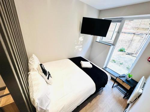 niewielka sypialnia z łóżkiem i oknem w obiekcie Central Studio Like a Hotel Room w Londynie