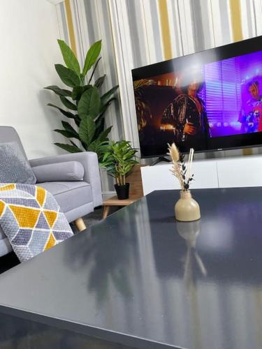 a living room with a table and a tv at Home in Medway Gillingham in Gillingham