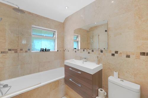 a bathroom with a sink and a toilet and a mirror at Special Offers, Sleeps 5, Hanwell, London W7, Free Parking in Greenford