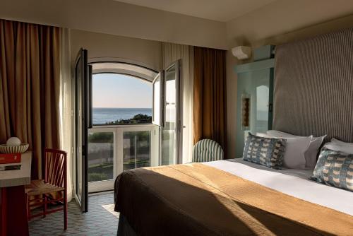 a hotel room with a bed and a large window at Regina Experimental Biarritz in Biarritz