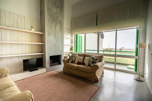 a living room with a couch and a fireplace at Casa dos Patos Quiaios in Figueira da Foz