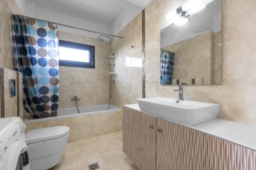 ein Badezimmer mit einem Waschbecken, einem WC und einer Badewanne in der Unterkunft #Luxlikehome Seashell Villa in Posidi