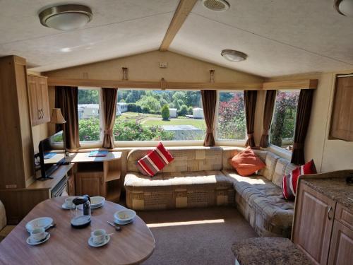 a caravan living room with a couch and a table at Cruachan Caravan and Camping Farm in Killin