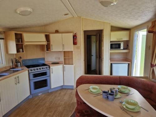 a small kitchen with a table in a caravan at Cruachan Caravan and Camping Farm in Killin