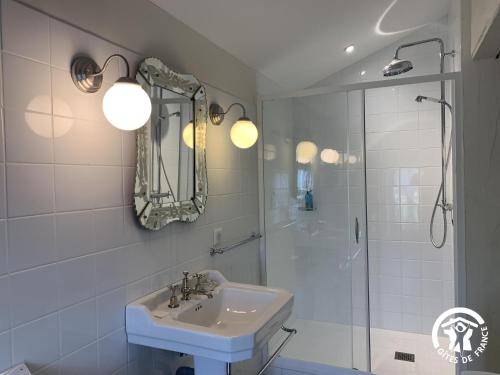 a white bathroom with a sink and a shower at Château de Gardès in Castin