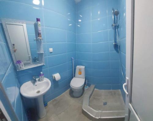 a blue bathroom with a toilet and a sink at Luka in Tbilisi City