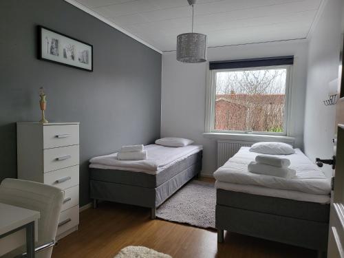 1 dormitorio con 2 camas y ventana en Villa nära Varberg och Ullared en Varberg