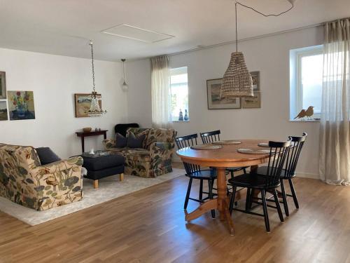 a dining room and living room with a table and chairs at Enkelheten i Kivik in Kivik