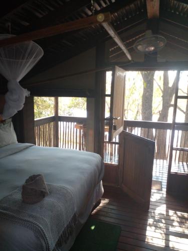 a bedroom with a bed with a hat on it at Nako Okavango Guesthouse in Ntabis