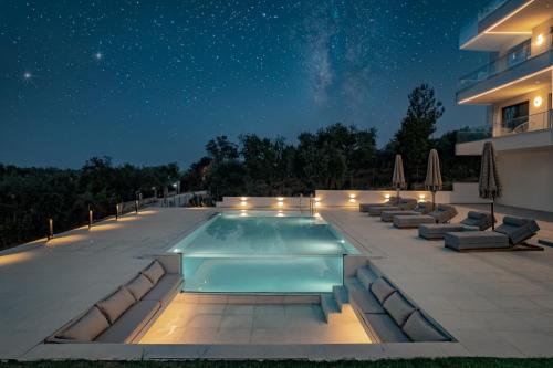 a swimming pool on a patio at night at OPSIS Suites in Limenaria