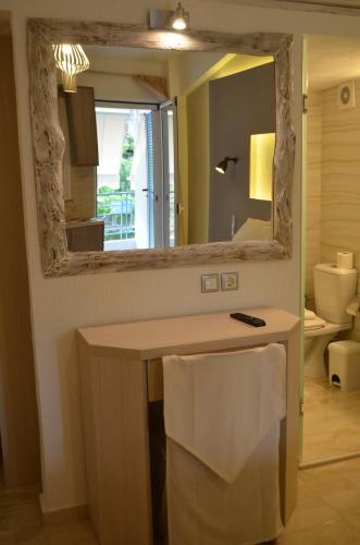 a mirror on a wall above a desk in a room at Ammos Apartments in Glida