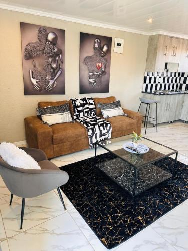 a living room with two couches and a table at The Pool_deck apartment in Lebowakgomo