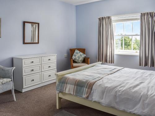 a bedroom with a bed and a dresser and a window at High Bank Farm in Cockfield
