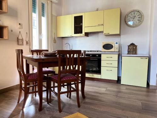 a kitchen with a table and chairs and a clock at Casa San Marco in Pisogne