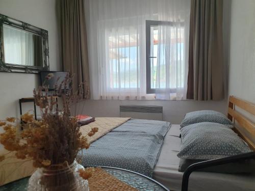 a bedroom with two beds and a table and a window at Apartman Relax Čelebići in Konjic