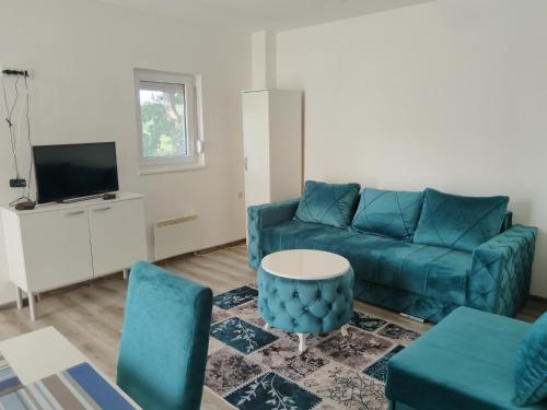 a living room with a blue couch and a table at Stari Hrast 1 in Prolomska Banja