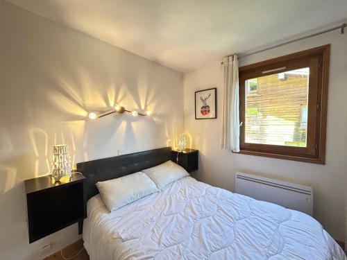 une chambre avec un lit et une fenêtre dans l'établissement Les Gets - Appartement rénové 3 étoiles, face aux pistes, balcon et parking - FR-1-623-294, aux Gets
