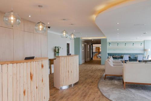 um átrio com painéis de madeira, uma mesa e cadeiras em Esplanade Hotel em Newquay