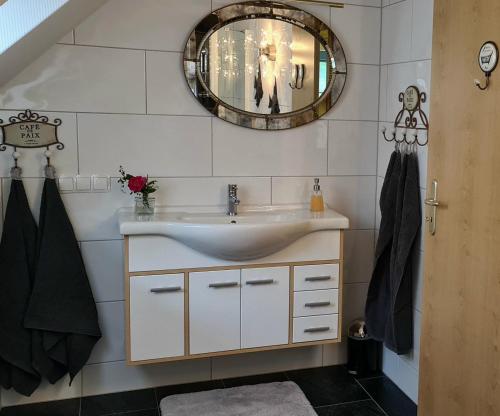 uma casa de banho com um lavatório e um espelho em Ferienwohnung Katinka Wiese em Burg