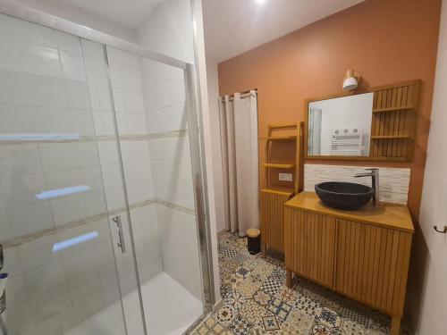 a bathroom with a glass shower and a sink at Le cocon paisible in Asté