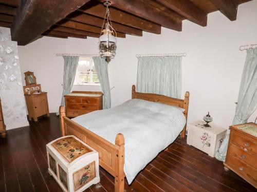 a bedroom with a wooden bed and a window at Windmill On The Farm in Ormskirk
